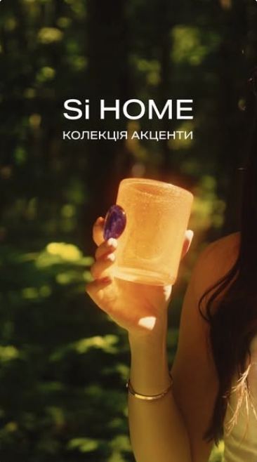 An amber glass held up in a sunlit forest, Si Home Accents collection